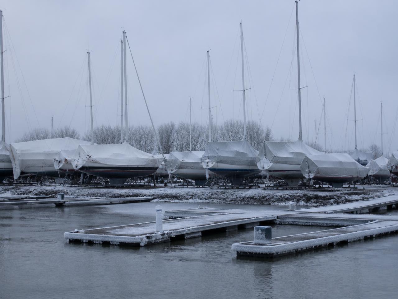 A frozen northern European marina with boats stored ashore for winter